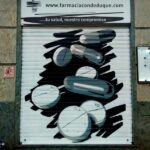 Graffiti en cierre de farmacia de Madrid.