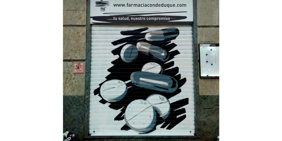 Graffiti en cierre de farmacia de Madrid.