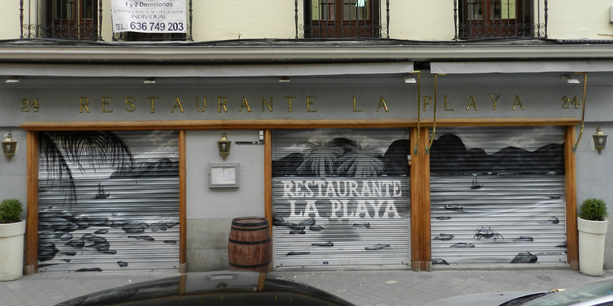 Graffiti en los cierres del restaurante La Playa en Madrid