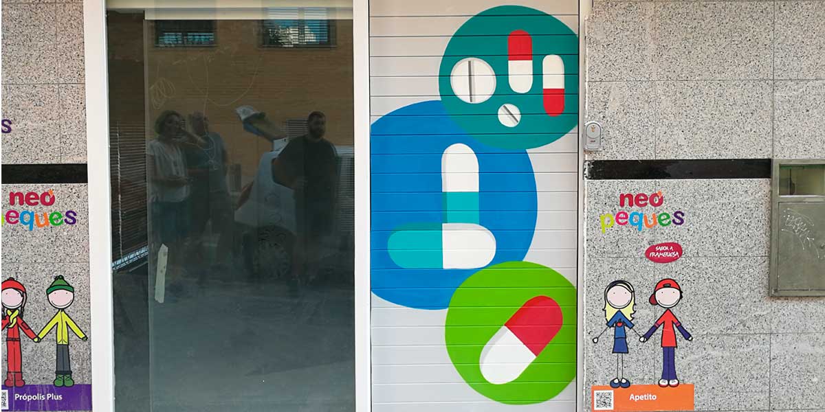 Graffiti profesional en cierre de farmacia de Madrid.