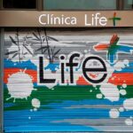 Graffiti en cierre metálico de clínica.