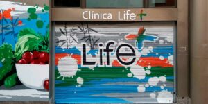Graffiti en cierre metálico de clínica.