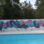Graffiti profesional de dragón chino en piscina.