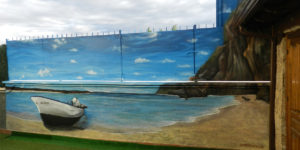 Mural de paisaje de playa con barca en patio