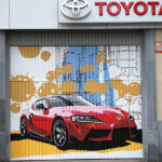 Graffiti profesional en puerta de concesionario Toyota.
