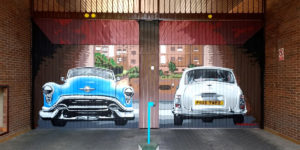 Graffiti de coches clásicos en puerta de garaje en Madrid