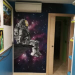 Mural decorativo de astronauta en habitación.